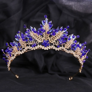 Détail d'une couronne de mariée dorée avec cristaux bleus et feuilles de strass