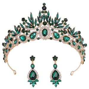 Macro shot of Baroque gold wedding tiara and drop earrings with emerald green crystals