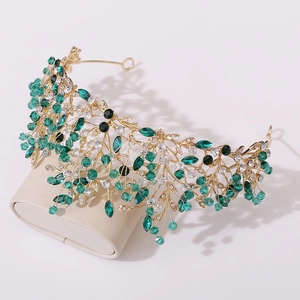 European bridal crown with golden leaf branches and emerald crystal beads on a stand