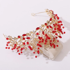 Detail of bridal crown with gold metal branches, red crystals and white rhinestones