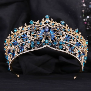 Détails de la pierre bleue en forme de goutte et strass sur une couronne baroque dorée