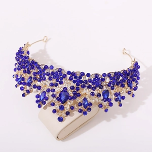 Detailed side view of Baroque golden crown with deep blue crystals and rhinestones
