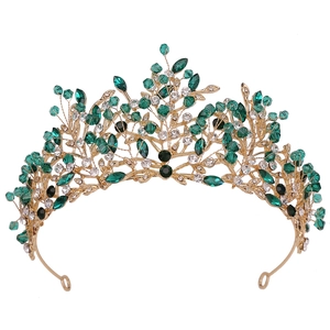 Detailed macro view of gold branch tiara with green marquise crystals and rhinestones