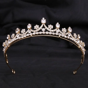 Detailed close-up of a gold bridal crown with shimmering white crystals on black fabric