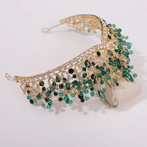 Detailed view of handmade bridal crown with gold metal, green beads, and crystals