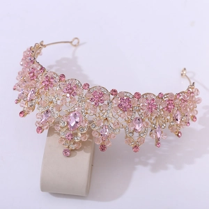 Detailed close-up of pink crystal bridal crown with golden floral leaf patterns