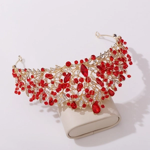 Détail d'une couronne de mariée dorée ornée de cristaux rouges et de pierres fines