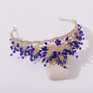 Détail macro d'une couronne de mariée en or avec cristaux bleu foncé et strass blancs