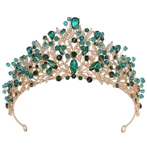 Détail de couronne de mariée dorée avec cristaux vert émeraude et design de branches