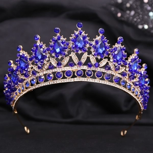 Detailed close-up of golden bridal tiara with royal blue crystals and sparkling rhinestones