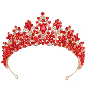 Detailed view of the handcrafted golden crown featuring deep red crystals and clear rhinestones