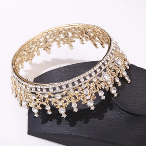 Close-up of golden Baroque bridal crown with crystals on black leather display