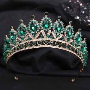 Macro shot of vintage gold bridal crown with emerald crystals and white stones