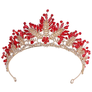 Détail d'une couronne de mariée en alliage doré avec cristaux rouges et feuilles strass
