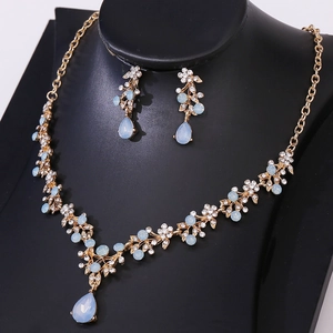 Detailed view of bridal rhinestone necklace and teardrop earrings set in light blue crystals
