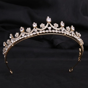 Elegant gold bridal tiara with sparkling white zircons on a black velvet background
