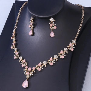 Detailed view of bridal rhinestone jewelry set with pink teardrop pendants and gold plating