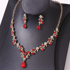 Close-up of gold bridal necklace set with red teardrop pendants and sparkling crystals