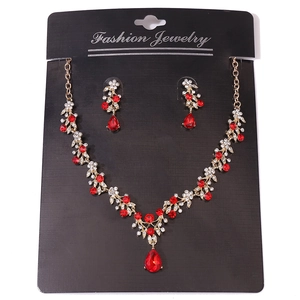 Detailed close-up of wedding jewelry set with red pear-cut rhinestones and gold finish