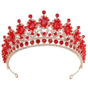 Detail of vintage red crystal bridal crown with golden leaf patterns and red gemstones