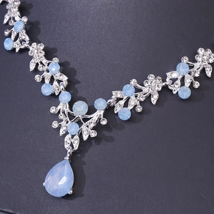 Detailed close-up of a silver-tone necklace featuring blue teardrop crystal pendant