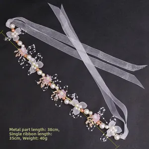 Detailed close-up of handmade floral headband with pearls, pink flowers and white ribbons