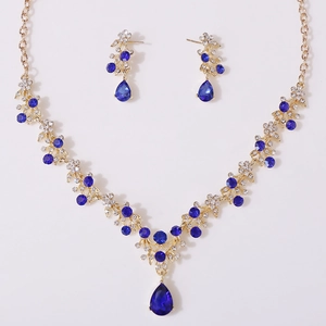 Detail of gold necklace set with blue teardrop rhinestones and sparkling crystals
