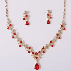 Detail of elegant gold V-neck necklace set with sparkling red teardrop rhinestones