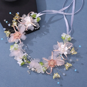 Detail of handmade bridal headband with pink flowers, golden butterflies and pearls
