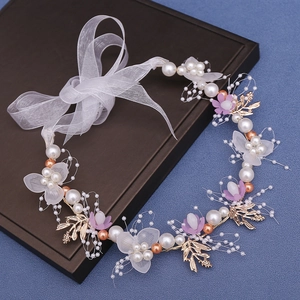 Detail of floral bridal headband with white pearls, purple flowers and gold leaves