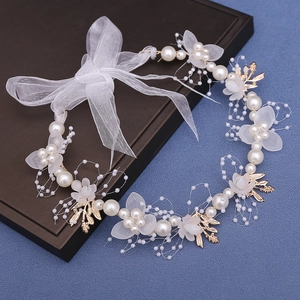 Close-up of white tulle petals and imitation pearls on a bridal flower headband