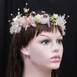 Detailed view of handmade pink floral bridal headband with satin bows and golden butterflies