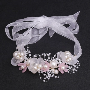 Detail of handcrafted floral headband with white petals, pearls and organza ribbon