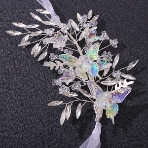 Handmade bridal hairband with crystal beads and iridescent butterfly on black background