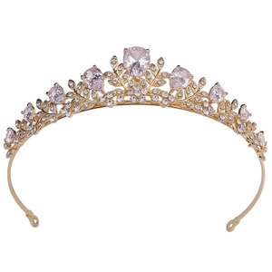 Close-up of golden alloy bridal crown with pear-shaped rhinestones and leaf patterns