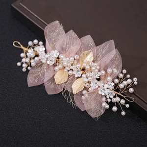 Detail of flower hair piece with white petals, pearls and golden metal leaves