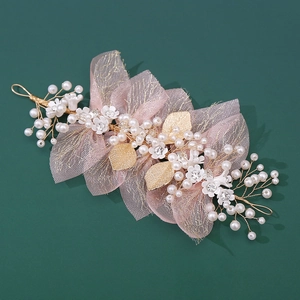 Close-up of handmade floral hairpiece with pink tulle, pearls and gold leaves