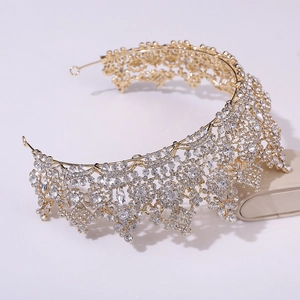 Gros plan d'une couronne de mariée dorée avec des motifs floraux en strass
