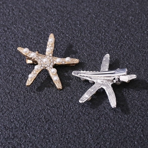 Detailed view of starfish hair pins with sparkling rhinestones and white pearls