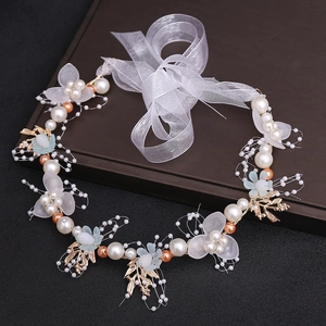 Detail of floral bridal headband with blue petals, white pearls and gold leaves