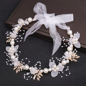 Detailed view of bridal headband with pearls, frosted petals, and organza bow knot