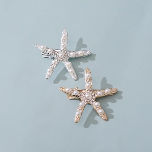 Macro detail of starfish hair clips with white pearls and sparkling crystals in gold and silver