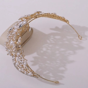 Détail d'une couronne de mariée dorée avec perles et strass au design floral baroque