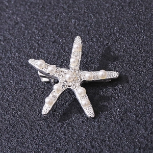 Close-up of starfish hair clip with faux pearls and rhinestones on silver base