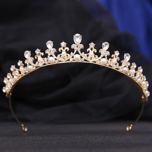 Detailed view of a gold princess crown with pearls, rhinestones, and a pear-shaped gem