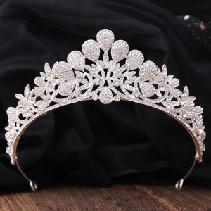 Elegant peacock alloy wedding crown with white rhinestones on dark silk background