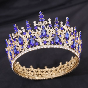 Detailed close-up of a gold baroque crown featuring blue crystal main stones and small rhinestones