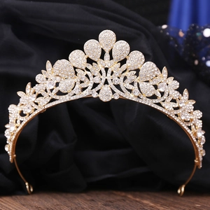Detail of luxury gold bridal crown featuring white rhinestones and floral alloy patterns
