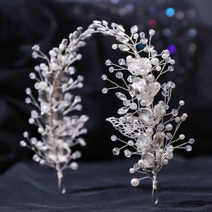 Close-up of handmade bridal headpiece with silver leaves, pearls, and crystals