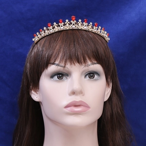 Vintage golden princess crown with red pear-shaped stones and white pearls on headband
